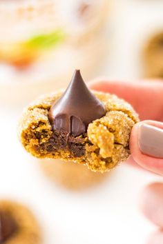 a hand holding a cookie with chocolate on top