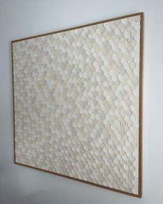 a white wall with a wooden frame hanging on it