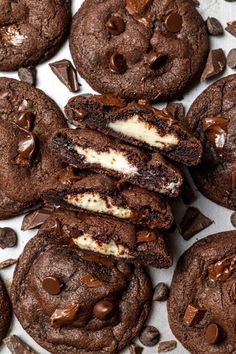 chocolate cookies and oreo cookies on a white surface with one cookie broken in half