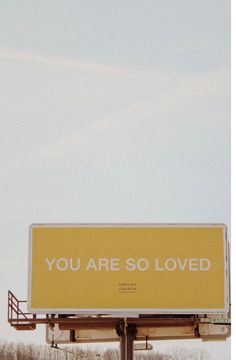 a billboard with the words you are so loved written on it in white and yellow