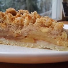 a piece of pie sitting on top of a white plate next to a glass window