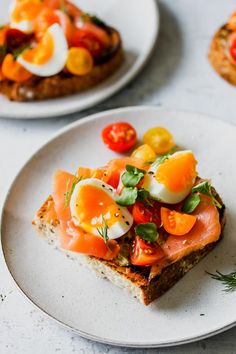 two white plates topped with food on top of a table