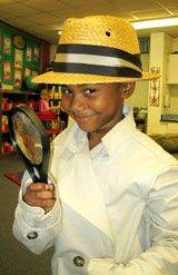 a young boy holding a magnifying glass and wearing a straw hat in an office