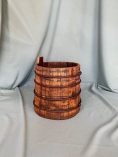 a wooden basket sitting on top of a white sheet