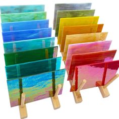 there are many different colored paintings on the easel stand, each painted with acrylic paint