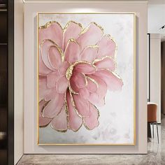 a pink and gold flower on a white wall in a room with marble flooring