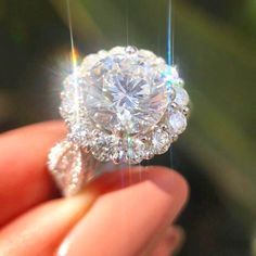 a person holding a diamond ring in their hand