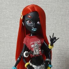 a black doll with red hair and blue eyes holding a hand up in the air