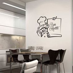 a kitchen with a table and chairs next to a wall that has a sign on it