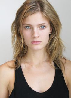 a young woman with blue eyes wearing a black tank top and looking at the camera