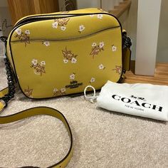 New Authentic Coach Floral Bow Camera Bag. Flax Yellow With Small Flowers And Bows In Pink Glitter. Black Hardware Adds A Nice Contrast. Adjustable Crossbody Mixed Chain Strap Is Removable. Front And Back Exterior Pockets. Slide In And Zipper Interior Pockets. Ring Zipper Pull With Fringe Accent. 8 Across X 6 High X 3 Deep. Dust Bag Included. Thanks For Shopping With Me. Coach Floral, Cream Bags, Coach Crossbody Purse, Brown Leather Crossbody Bag, Vintage Gloves, Hippie Bags, City Bag, Coach Crossbody Bag, Slide In