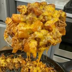 a skillet full of food being lifted from the stove top by a spatula