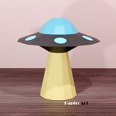 a blue and black object sitting on top of a wooden table next to a pink wall