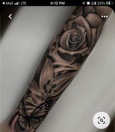 a black and white rose with a butterfly on it's arm, done by tattoo artist