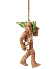 a christmas ornament with a tree on it's head and a bear carrying a bag