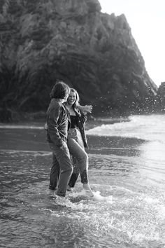 black and white photograph of two people standing in the water