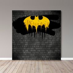 the batman symbol is painted on a brick wall in an empty room with hardwood flooring