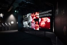 the dark room has three large screens displaying images on it and two chairs in front of them