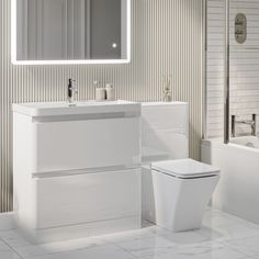 a white toilet sitting next to a sink in a bathroom under a large mirror above it