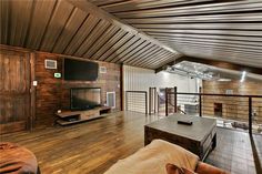 a living room filled with furniture and a flat screen tv on top of a wooden table