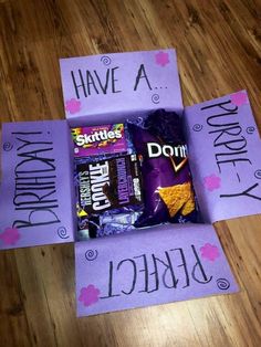 a purple box with some candy in it on top of a wooden floor next to a sign that says, i have a birthday party