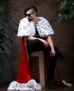 a man sitting on top of a wooden chair wearing a fur stoler and sunglasses