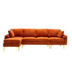 an orange sectional sofa with gold legs and foot rests on a white background in front of a white backdrop