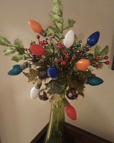 a vase filled with lots of colorful balloons and greenery on top of a table