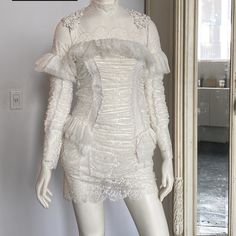 a mannequin is dressed in white with ruffles