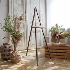 some plants are sitting in baskets on the floor next to a wooden crate and an old door