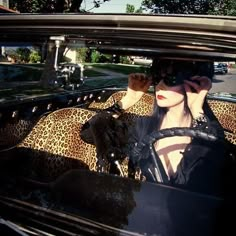 a woman sitting in the back seat of a car with her hand on her head