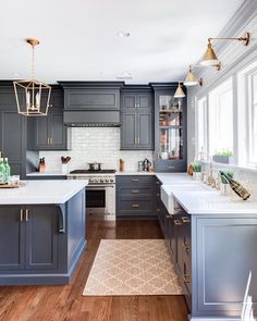 a kitchen with gray cabinets and white counter tops