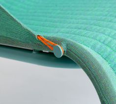 a close up view of the inside of a green chair with an orange stitch on it