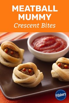 meatball mummy crescent bites on a brown plate with a bowl of ketchup