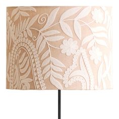 a table lamp with a white and beige floral design on the fabric, which is attached to a black metal base