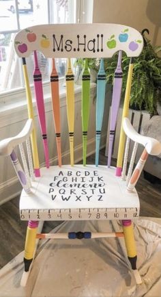 a wooden chair with crayons on it and the word math painted on it