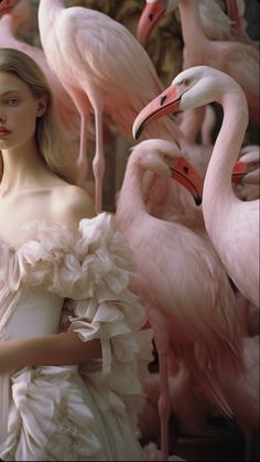 a woman in a white dress surrounded by pink flamingos