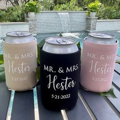 three personalized can coolers sitting on top of a table next to a pool