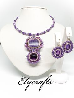 This handmade jewellery set is made with 100% natural Amethyst and Charoite stones. The necklace is 21 cm long from the top to the bottom of the pendant and 13 cm wide. The pendant is 7 cm long and 4.5 cm wide. The Charoite stone is 29x21.5 mm, the Amethyst is 21 mm, 33 carats. The earrings are made with 2 pcs 100% natural faceted Amethyst -12 carats, 14x10 mm. The ear wires and the necklace lobster clasp are sterling silver. The earrings are 4 cm long from the top of the wires to the bottom and 2.5 cm wide. Handmade Amethyst Pendant Beaded Necklaces, Handmade Amethyst Pendant Beaded Necklace, Handmade Purple Jewelry Sets As Gift, Beaded Amethyst Pendant Jewelry, Amethyst Beaded Pendant Jewelry, Amethyst Beaded Jewelry Gift, Amethyst Beaded Jewelry For Gift, Embroidery Jewellery, Seed Bead Embroidery