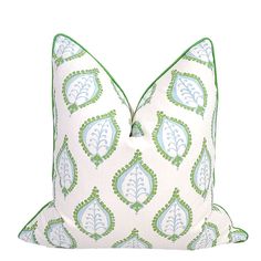 a green and white pillow with a decorative design on the front, sitting against a white background