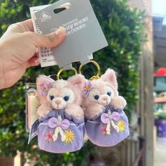 two stuffed animals are hanging from a key chain in front of a card and tree