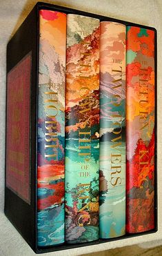 the four books are lined up on the wall in front of each other, all different colors