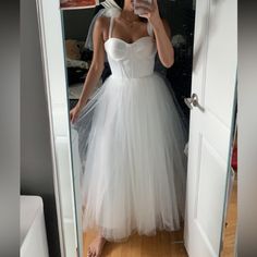 a woman in a white dress taking a selfie