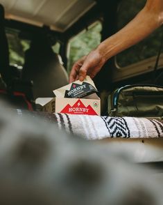 a person unpacking boxes in the back of a car with their feet propped up