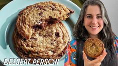 a woman holding a cookie next to a plate of cookies