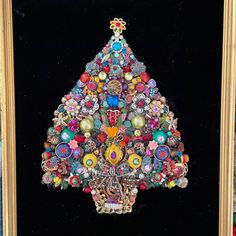 a colorful christmas tree made out of many different colored beads and brooches in a gold frame