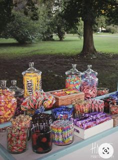 a table filled with lots of candy and candies on it's sides under an umbrella