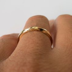 a person's hand with a gold ring on it