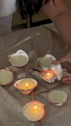 a person lighting candles in shells on a table