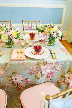 the table is set with pink and white flowers